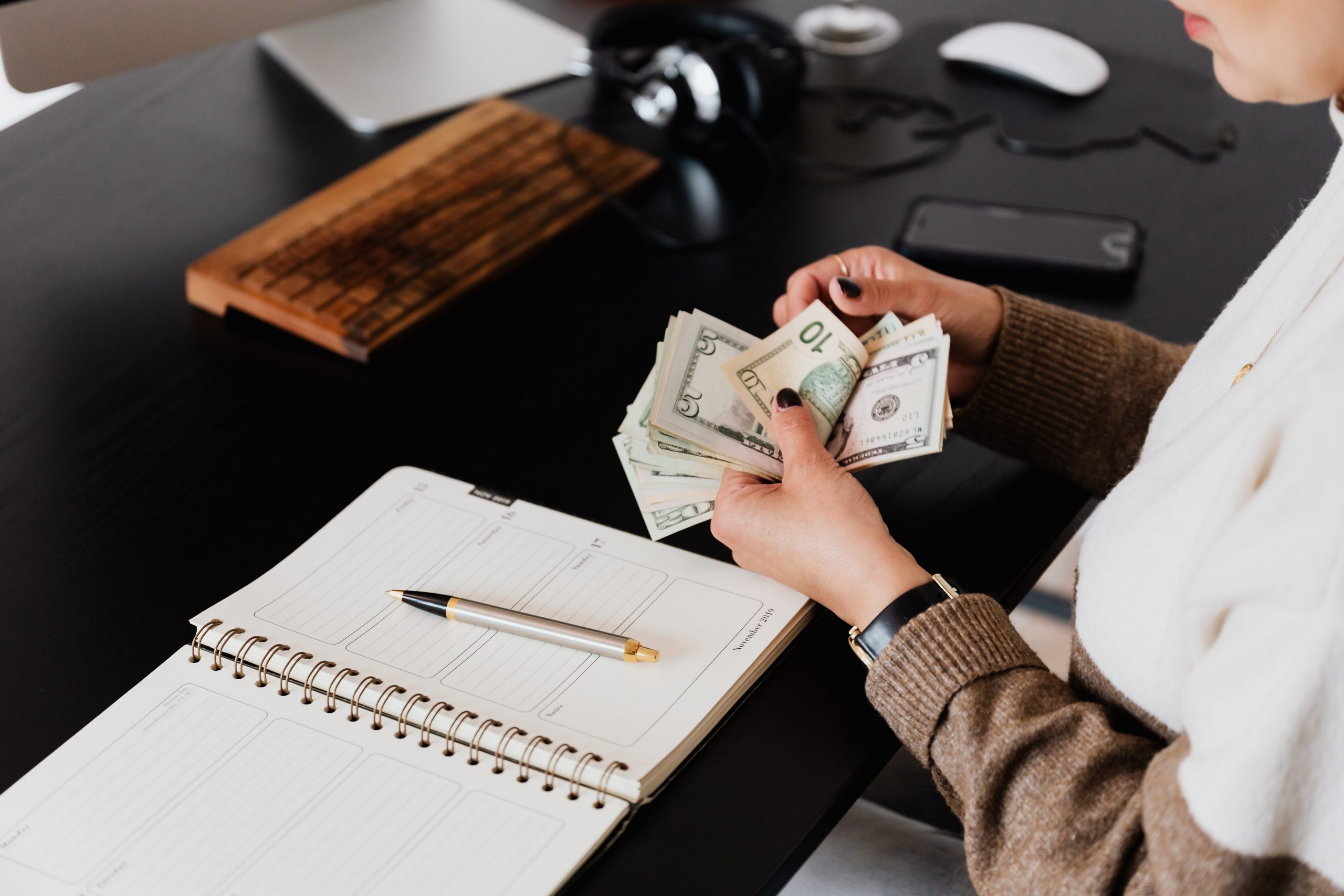 Business owner reviewing financial documents and calculator while learning bookkeeping vs accounting differences