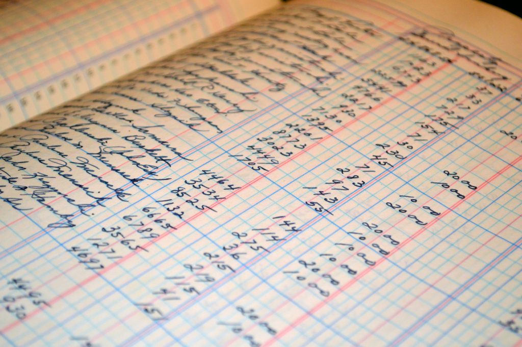 Professional bookkeeper organizing financial documents and ledgers for comprehensive business accounting services