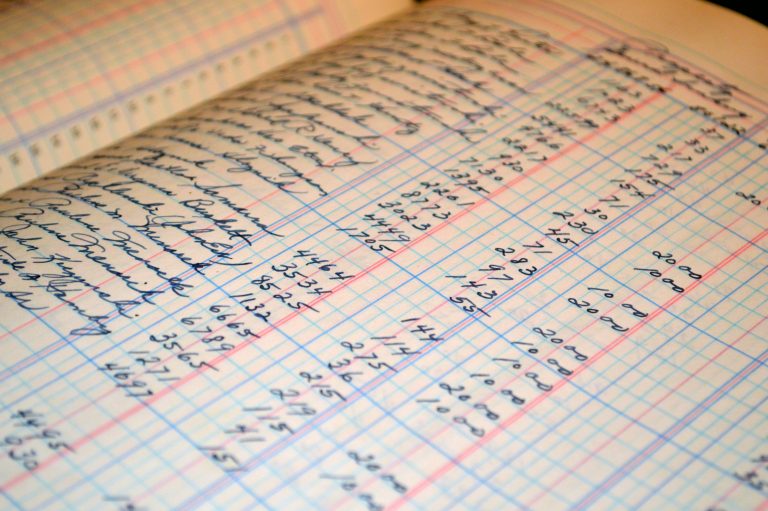 Professional bookkeeper organizing financial documents and ledgers for comprehensive business accounting services